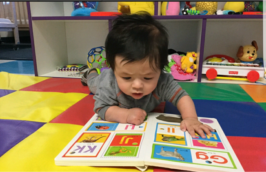 Baby looking at book on floor